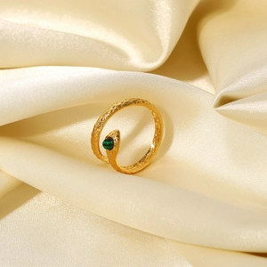 Macro shot of 18K gold plated snake ring with green malachite stone on silk fabric
