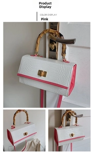 Detail of crocodile pattern leather bag with bamboo handle and pink trim in macro view