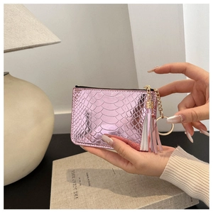 Detailed macro of pink metallic snakeskin pattern coin purse with tassel and keychain