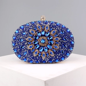 Close-up of blue floral rhinestone pattern and golden crystal clasp on luxury evening bag