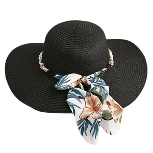 Chapeau de paille noir à larges bords orné de perles élégantes et d'un ruban à fleurs