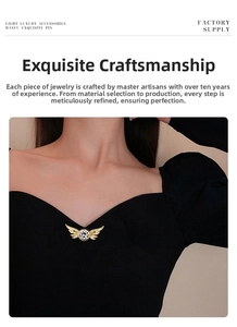 Detailed view of luxury gold wing brooch with sparkling central diamond on black clothing