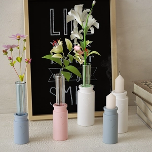 Detail of heart-shaped vase base with glass test tube and white candle in soft blue tone