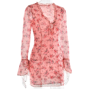 Détail de la robe fleurie rose avec décolleté en V à volants et manches longues évasées