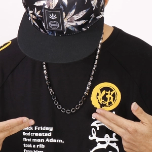 Close-up of a trendy black stainless steel hip-hop chain necklace worn by a male model