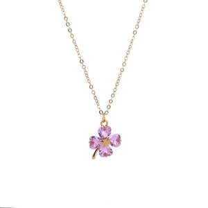 Detail of gold clover necklace with four purple heart-shaped stones and small gold petal