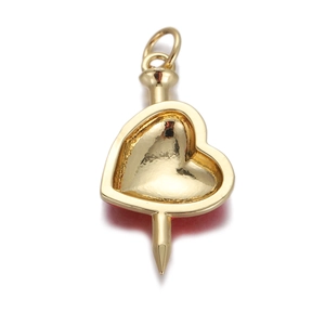 Detailed view of a gold-plated heart-shaped pendant with red enamel and a pointed nail tip