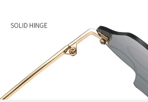 Detailed close-up of sturdy gold metal hinges and grey polarized lenses on sunglasses