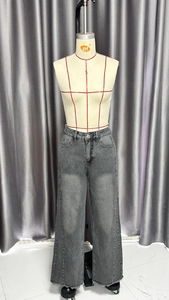 Gros plan d'un jean large taille haute gris foncé avec denim délavé et ourlet brut