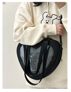 Black heart-shaped Ita bag with clear window shown worn as a crossbody on a model