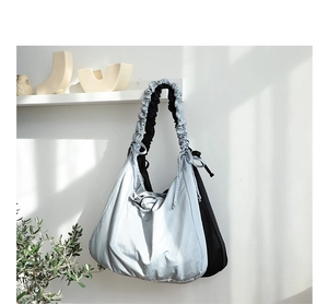 Detail of grey-blue nylon shoulder bag featuring creative ruched elastic strap design
