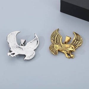 Detail view of eagle pendants in gold and silver showing intricate feather textures