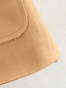 Gros plan d'une veste en daim camel montrant la texture et les coutures de précision