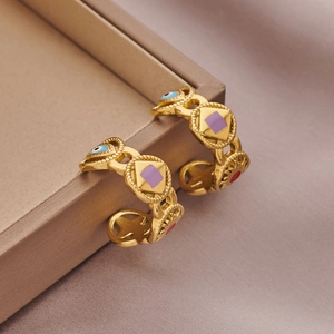 18k gold plated open ring featuring colorful enamel patterns on a beige jewelry box edge