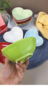 Detail view of colorful heart-shaped ceramic bowls with textured pastel glazed finish