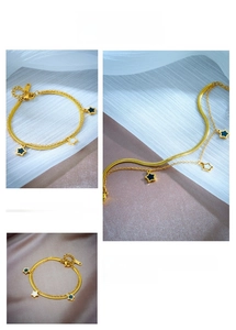Detailed macro view of gold double-layer chain bracelet with star enamel charms