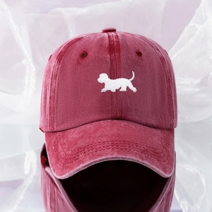 Close-up of embroidered puppy motif on burgundy washed cotton baseball cap texture