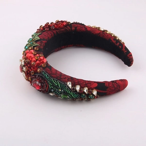 Baroque style sponge headband with red crystals and beaded leaf patterns on dark brocade