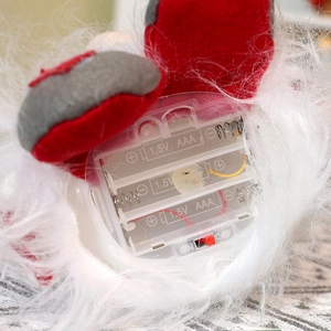 Macro detail of the battery compartment and power switch on the plush Christmas doll base
