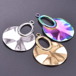 Detailed view of irregular wavy hammered metal pendants in gold, silver, and rainbow finishes
