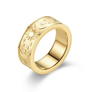 Detailed macro view of celestial star and moon embossed patterns on a matte gold ring band