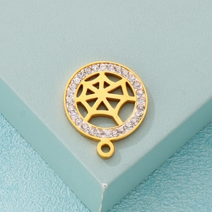 Gold stainless steel spider web pendant with sparkling zircons on a blue pedestal