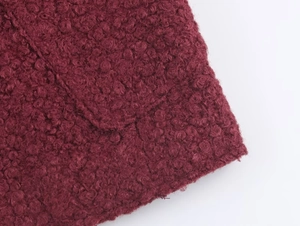 Close-up of wine red boucle wool fabric texture and pocket detail on French style jacket