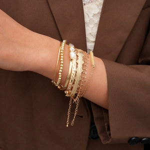Detail of 7-piece gold geometric bracelet set with layered bangles and water-drop zircons