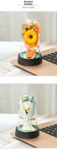 Preserved sunflower and rose in glass dome with warm LED lights on a black base