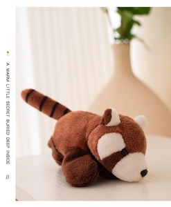 Close-up of a cute brown plush red panda slap bracelet on a cozy blurred home background