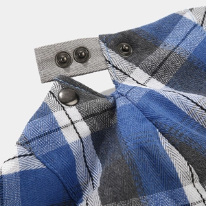 Détail de la fermeture à bouton en métal et texture à carreaux gris-bleu de la casquette