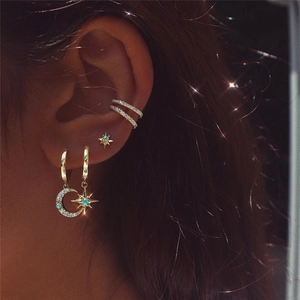 Detail of S925 silver star and moon earrings set with blue opal and sparkling diamonds
