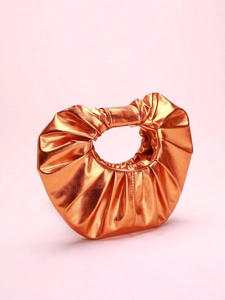 Close-up of metallic orange cloud clutch bag with pleated texture and glossy finish