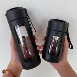 Macro detail of black matte portable water bottles with clear window and handle rope
