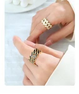 Detailed shot of black and white enamel cross pattern on gold titanium steel rings
