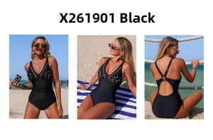Visuale a tre lati del costume intero nero con aperture e fibbia su una spiaggia soleggiata