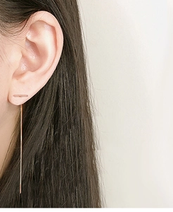 Detailed view of rose gold S925 sterling silver tassel earrings worn by a model