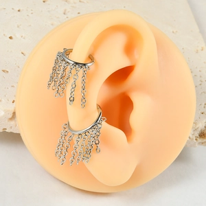 Detail of silver steel hoop earrings with hanging metal chains on silicone ear model