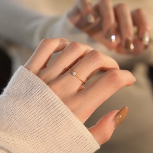 Minimalist S925 sterling silver gold ring with a single white zircon on a model's hand