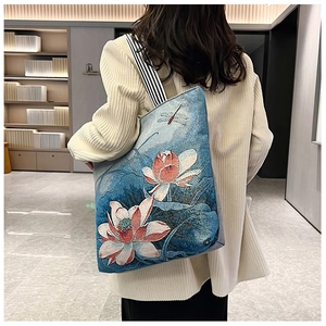 Blue canvas tote with embroidered pink lotus flowers and striped shoulder straps