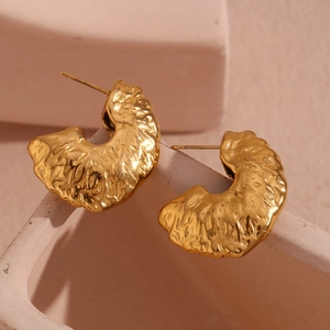 Macro shot of 18K gold plated fan-shaped earrings with unique hammered texture details