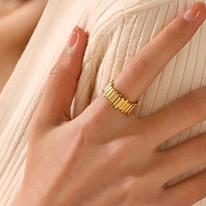 Minimalist 18K gold plated stainless steel ring with elegant ripple texture on a model