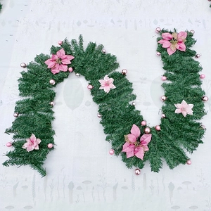 Green PVC Christmas garland with pink poinsettia flowers and decorative baubles