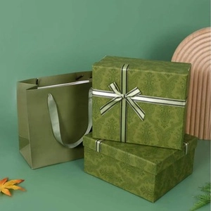 Detail view of green gift box with vintage botanical patterns and striped ribbon bow