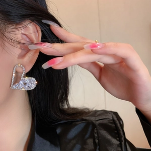 Close-up of heart-shaped silver stud earrings with sparkling marquise-cut cubic zirconia