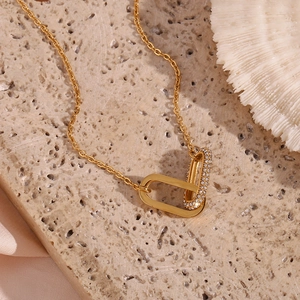Detailed close-up of gold interlocking double ring pendant necklace with crystal pave setting