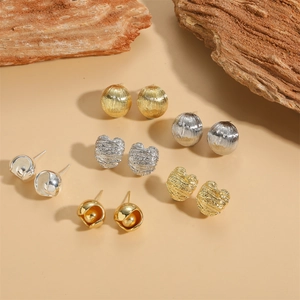 Minimalist metallic stud earrings in gold and silver finish with textured surface
