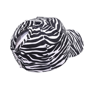 Detail of zebra stripe baseball cap featuring a back ponytail hole and metal buckle