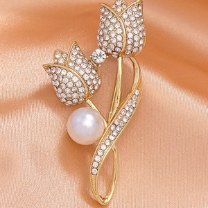 Elegante goldene Tulpenbrosche mit funkelnden Strasssteinen und einer weißen Perle auf Seide