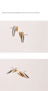Detail of two-tone gold and silver rivet stud earrings with a high-polished mirror finish